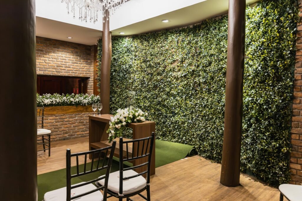 Charming indoor venue with brick walls, floral arrangements, and greenery suitable for events.